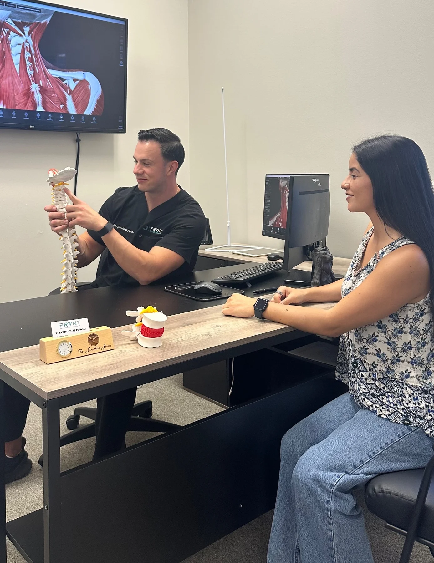 PRVNT clinician reviewing a spine model during a consultation.